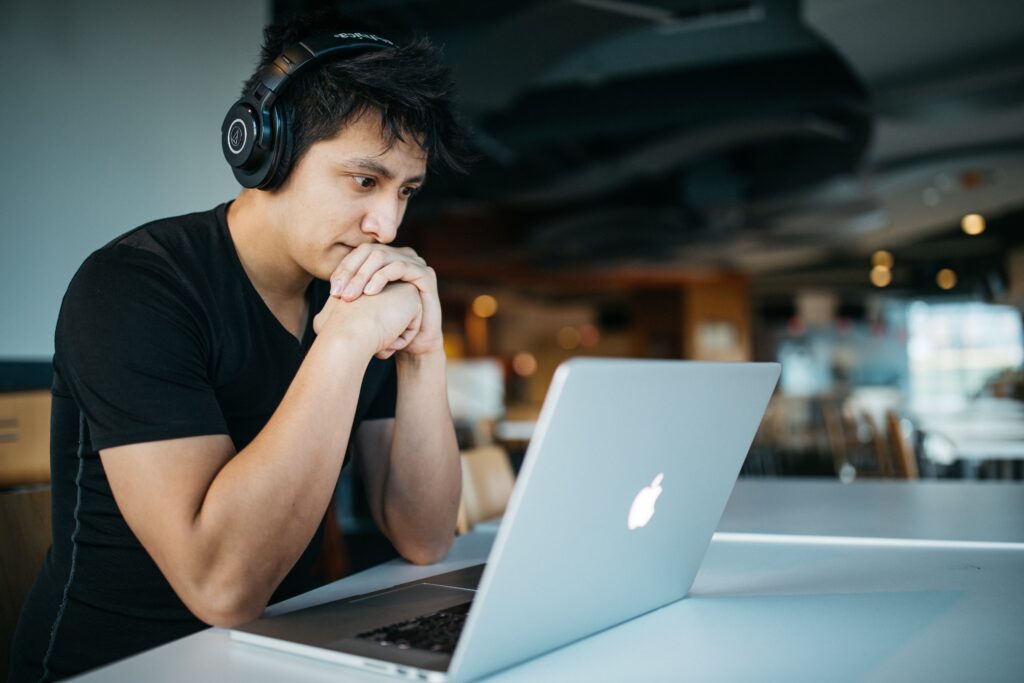 a man wearing black t-shirt and attending online lectures from gray color MacBook Digital marketing course with internship